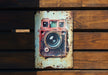 an old camera mounted to a wooden wall