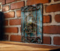 a bird in a cage on a brick wall