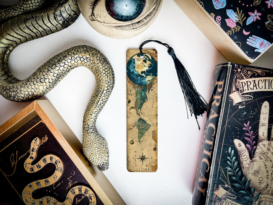 a bookmark with a snake on it next to other books