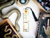 a bookmark with a snake on it next to other books