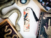 a bookmark with a bird on it next to a snake