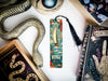 a bookmark with a snake on it next to other books