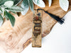 a wooden bookmark with a tassel hanging from it