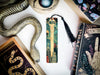 a bookmark with a snake on it next to other books