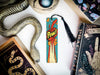 a bookmark with the word powi on it next to a snake