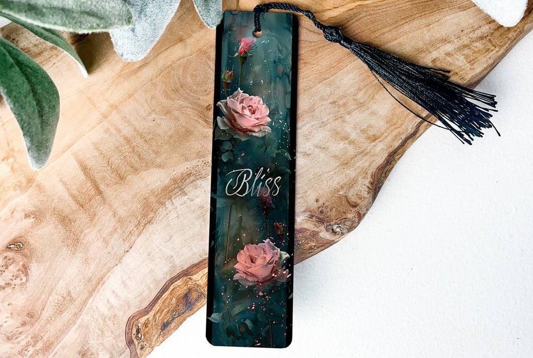 a bookmark with flowers and a tassel on a wooden table