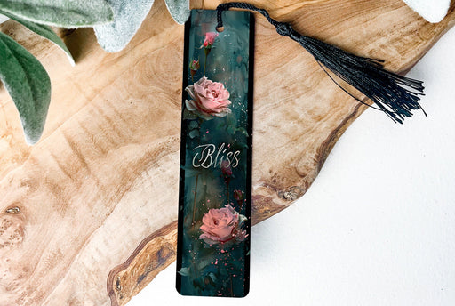 a bookmark with flowers and a tassel on a wooden table