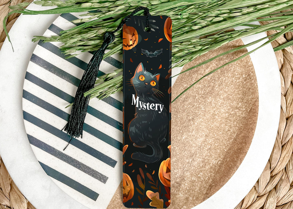 a bookmark with a cat and pumpkins on it