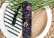 a purple flower bookmark sitting on top of a plate