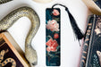 a bookmark with flowers and a snake on it