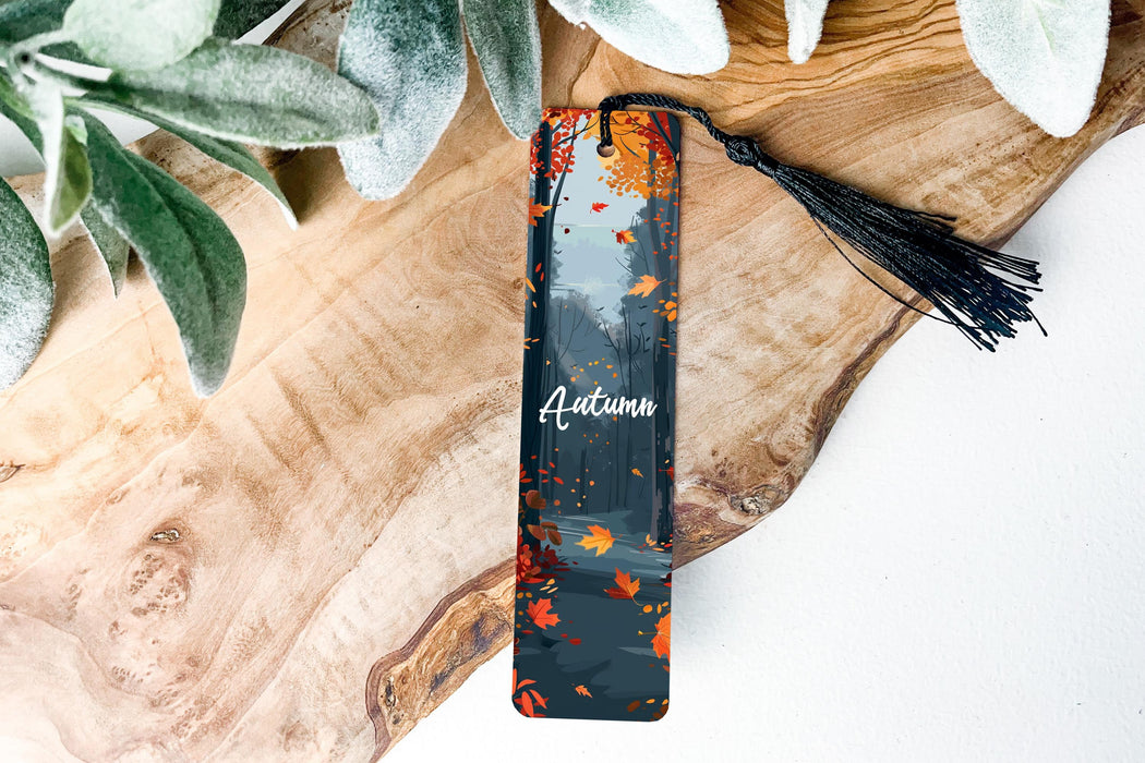 a bookmark sitting on top of a wooden table next to a plant