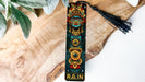 a bookmark with a tassel on top of a piece of wood
