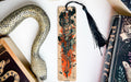 a snake, a bookmark, and two books on a table