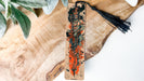a piece of wood with a tassel hanging from it