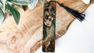 a bookmark with a painting of a woman holding a baby