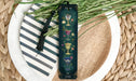 a green bookmark with flowers and a tassel on a plate