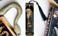 a bookmark with a snake and a book on it