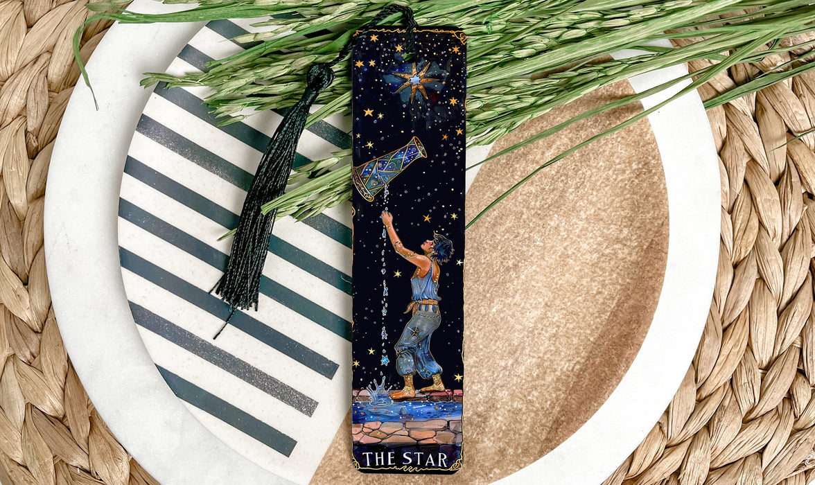 a bookmark with a picture of a man reaching for the stars