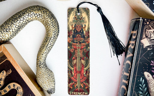 a snake, a bookmark, and two books on a table