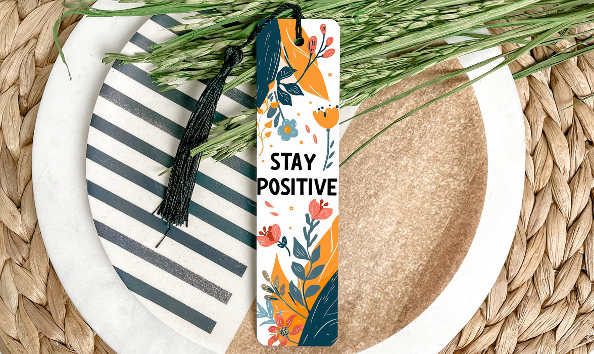 a bookmark that says stay positive on a plate