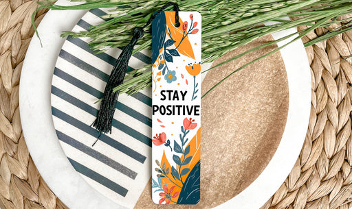 a bookmark that says stay positive on a plate