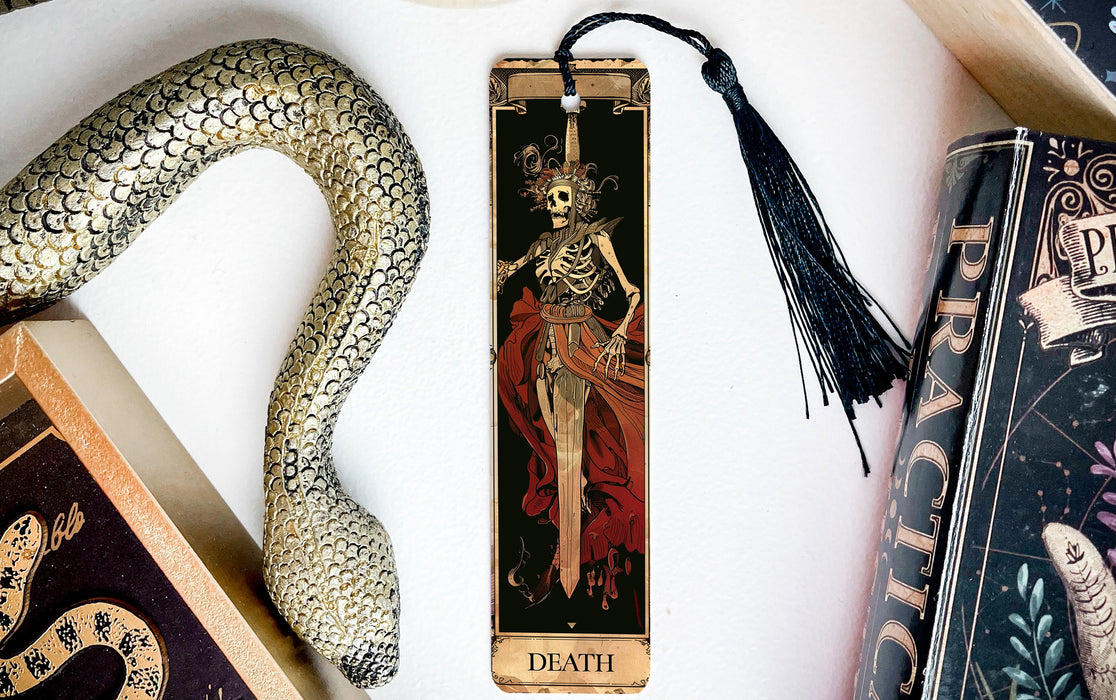 a bookmark with a skeleton on it next to a snake