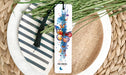 a bookmark with a butterfly on it sitting on a plate