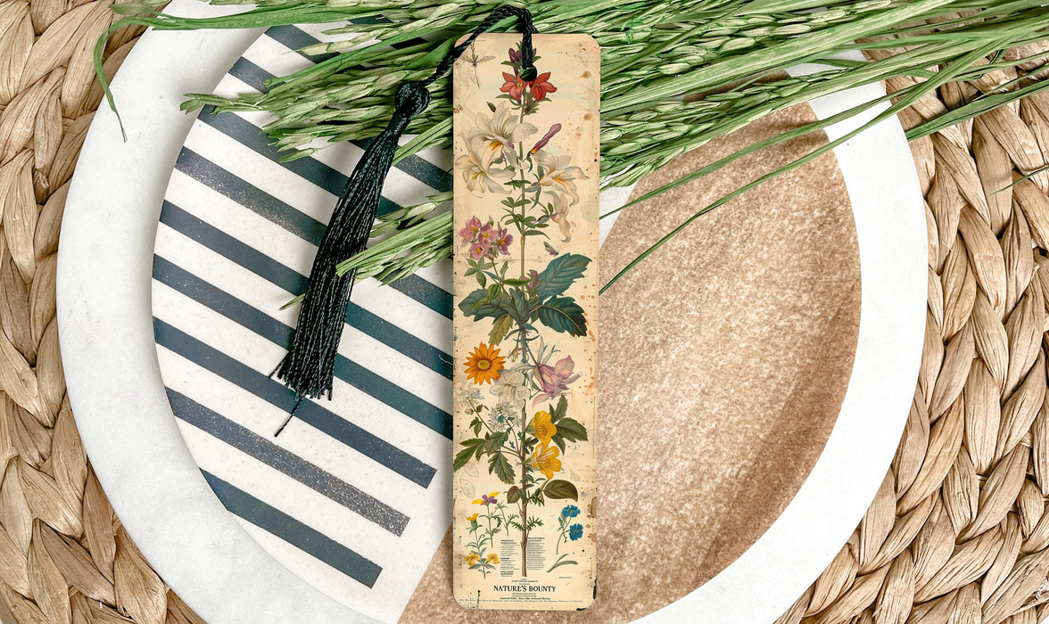 a bookmark with flowers and a tassel on a plate