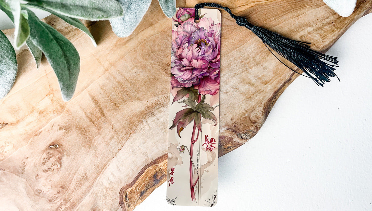 a bookmark with a flower and a tassel hanging from it