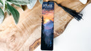 a bookmark with a painting of a mountain scene