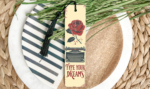 a bookmark with a rose on it sitting on a plate