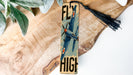 a wooden sign that says fly high on it