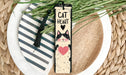 a bookmark with a cat on it on a plate