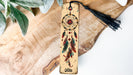 a wooden bookmark with a tassel hanging from it