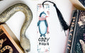 a bookmark with a penguin and a snake on it