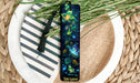 a bookmark on a plate next to a plant