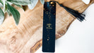 a bookmark with a tassel on top of a wooden table