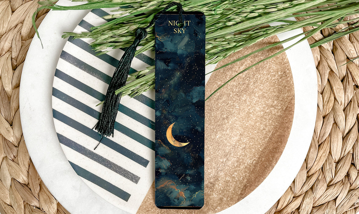 a bookmark sitting on top of a plate next to a plant