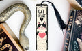 a bookmark with a cat on it next to a snake