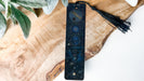 a wooden board with a tassel on top of it