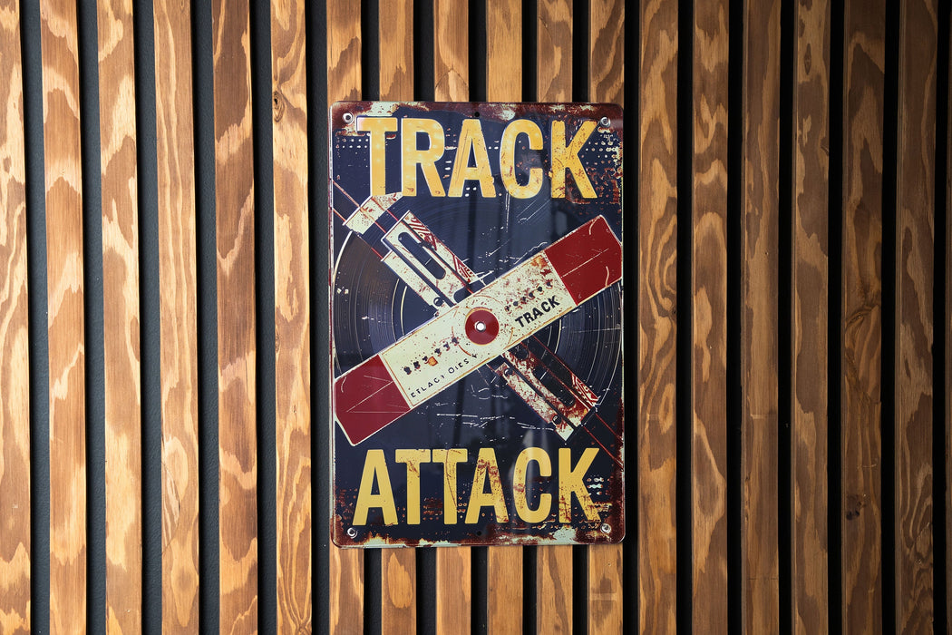 a sign on a wooden wall that says track attack