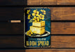a metal sign with yellow flowers on it