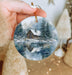 a person holding a christmas ornament in their hand