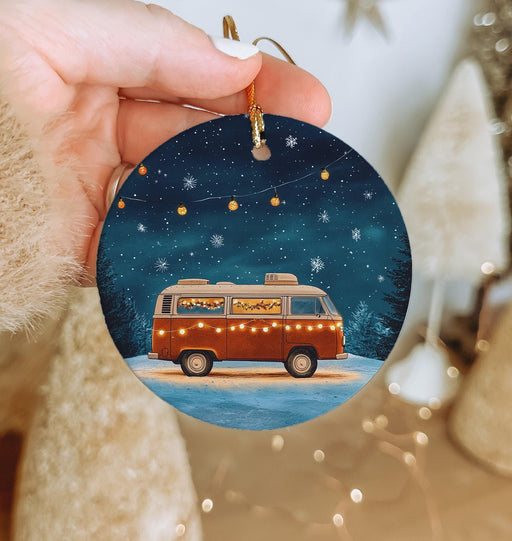 a person holding a christmas ornament with a van on it