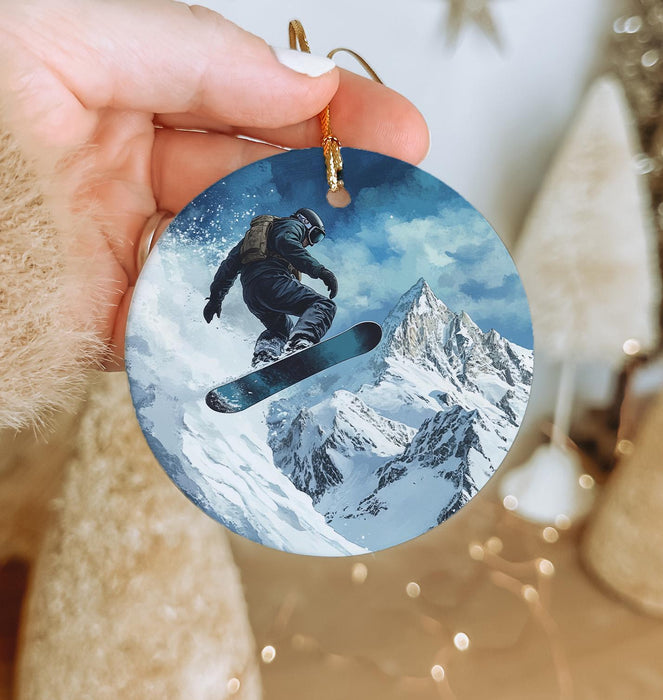 a person holding a snowboard ornament in their hand