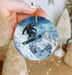 a person holding a snowboard ornament in their hand