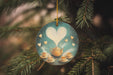 a glass ornament hanging from a christmas tree