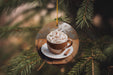 a cup of hot chocolate is hanging from a tree