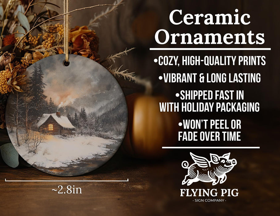 a ceramic ornament with a picture of a cabin in the snow