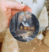 a person holding a christmas ornament in their hand